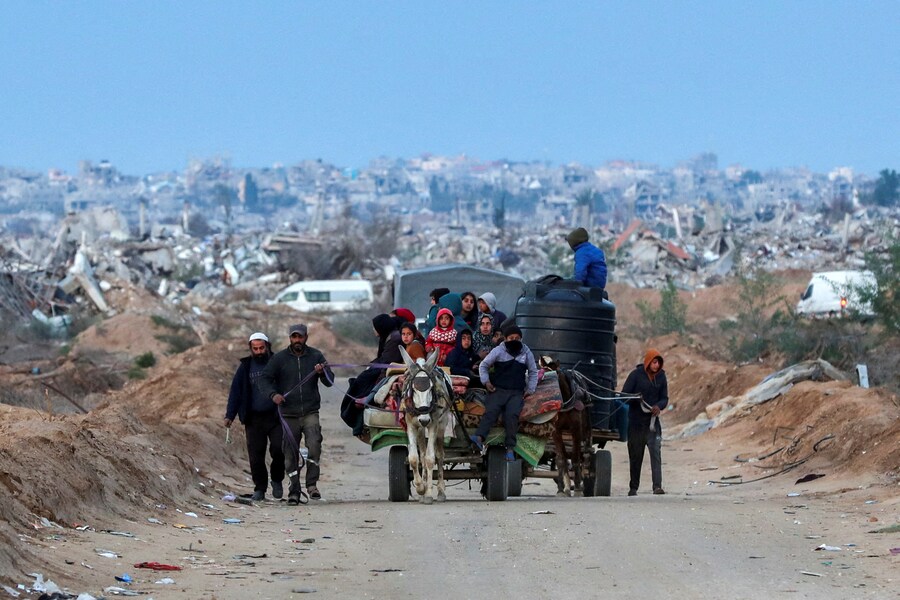 I palestinesi si fanno strada dopo che le forze israeliane si sono ritirate dal corridoio Netzarim, consentendo alle persone di viaggiare in entrambe le direzioni tra il sud e il nord di Gaza. (REUTERS)