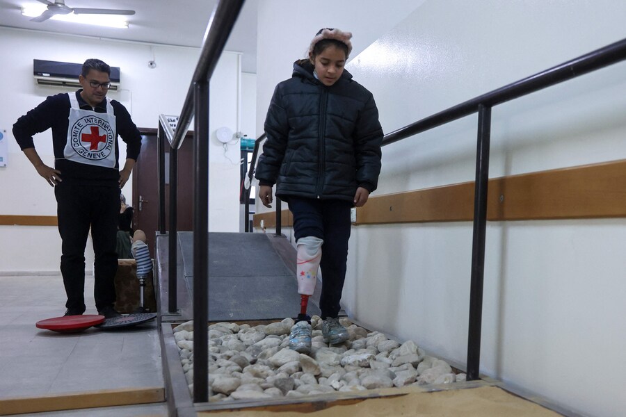 Retaj Juha, una bambina di nove anni, che ha perso una gamba a seguito di un attacco israeliano alla sua casa nel quartiere di al-Tuffah a Gaza City il 6 dicembre 2023, prende parte a un programma di riabilitazione presso il Gaza Polio and Prosthetics Center a Deir el-Balah. (AFP)