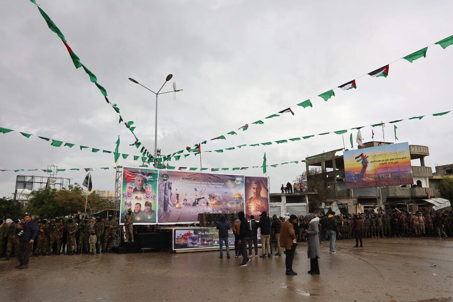 Combattenti e giornalisti di Hamas si riuniscono sul luogo della consegna degli ostaggi israeliani a Rafah, nel sud della Striscia di Gaza, nell’ambito del settimo rilascio di ostaggi e prigionieri, il 22 febbraio 2025. (AFP)