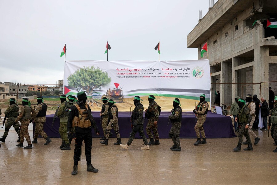 I combattenti di Hamas si riuniscono nel luogo della consegna degli ostaggi israeliani nel campo profughi di Nuseirat, nel centro della Striscia di Gaza, come parte del settimo rilascio di ostaggi e prigionieri, il 22 febbraio 2025. L’ala armata di Hamas ha confermato che consegnerà il 22 febbraio sei ostaggi tenuti vivi nella Striscia di Gaza come parte dell’accordo di cessate il fuoco in corso con Israele. (AFP)
