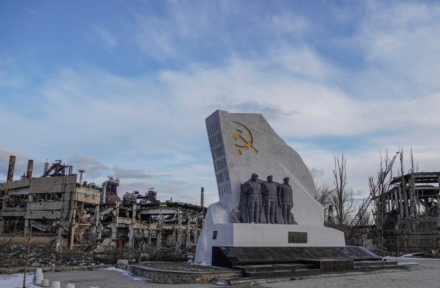 Un monumento restaurato con l’iscrizione: “L’impresa non muore mai, la gente ne conserva la memoria” visto attraverso l’acciaieria demolita Azovstal a Mariupol, nella regione di Donetsk, il 16 febbraio 2025 (pubblicato il 21 febbraio 2025). L’acciaieria Azovstal fu teatro di una grande battaglia tra le forze ucraine e russe. (EPA)