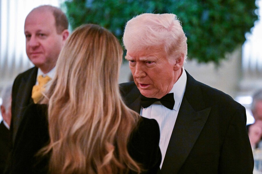 Il Presidente degli Stati Uniti Donald Trump parla con la First Lady Melania Trump durante la cena e il ricevimento della National Governors Association nella East Room della Casa Bianca a Washington. (AFP)