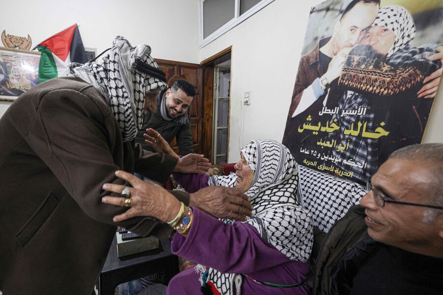 La madre del prigioniero palestinese Khaled Khdeish, che sarà rilasciato insieme a centinaia di prigionieri palestinesi, viene accolta dai parenti mentre guarda le notizie in attesa di informazioni sul suo rilascio nella sua casa nel campo di Balata, a est di Nablus, nella Cisgiordania occupata, il 22 febbraio 2025. (AFP)