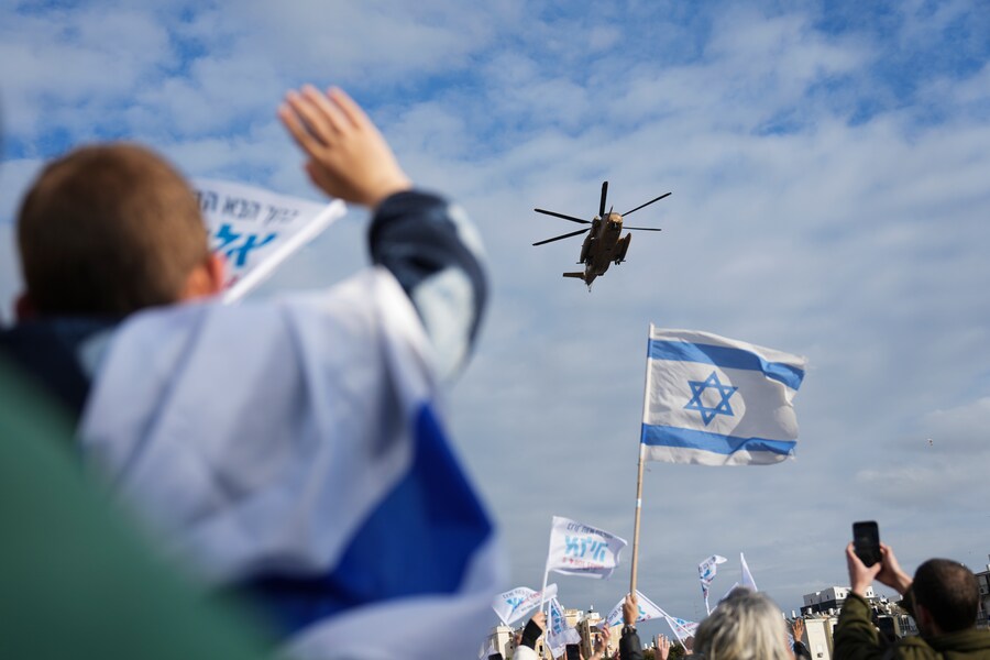 Cittadini israeliani accolgono l’elicottero militare che trasporta due ostaggi israeliani liberati, Omer Shem Tov ed Eliya Cohen, arriva all’ospedale Beilinson di Petah Tikva, Israele, dopo essere stati liberati dalla prigionia di Hamas nella Striscia di Gaza, sabato 22 febbraio 2025. (APN)