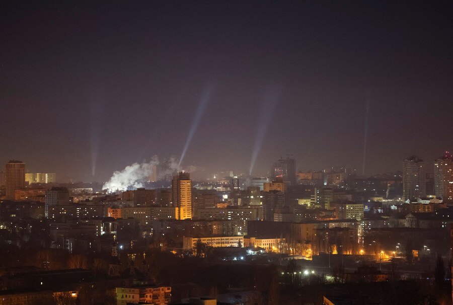 I proiettori illuminano il cielo sopra la città in cerca di droni durante un attacco russo a Kiev, Ucraina. 23 febbraio 2025. (REUTERS)