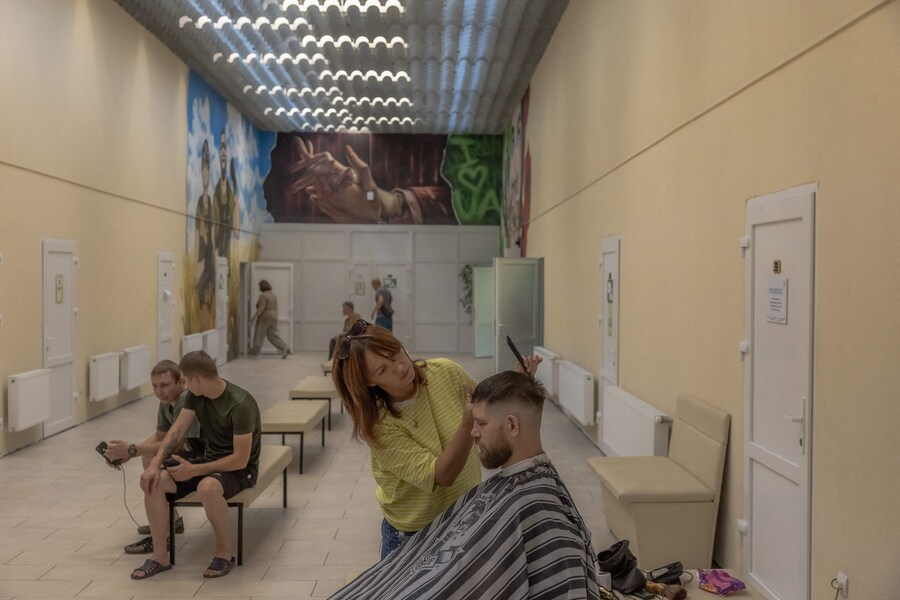 I militari e i veterani ucraini in fase di riabilitazione si fanno tagliare i capelli da parrucchieri volontari presso il Centro di salute mentale Lissova Poliana, a Kiev. (AFP)