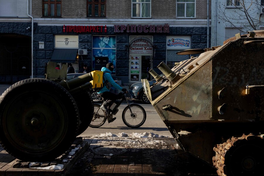 Un rider passa vicino alla mostra all’aperto di veicoli militari russi distrutti nel Museo nazionale di storia militare di Kiev. (Tetiana Dzhafarova / AFP)