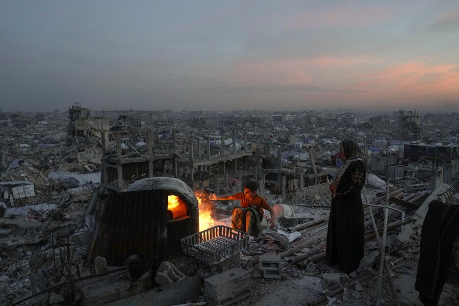 Ali Marouf e sua madre Aisha cucinano sul fuoco sul tetto della loro casa, distrutta dall’offensiva aerea e terrestre dell’esercito israeliano, a Jabaliya, nella Striscia di Gaza (AP Photo/Jehad Alshrafi) (APN)