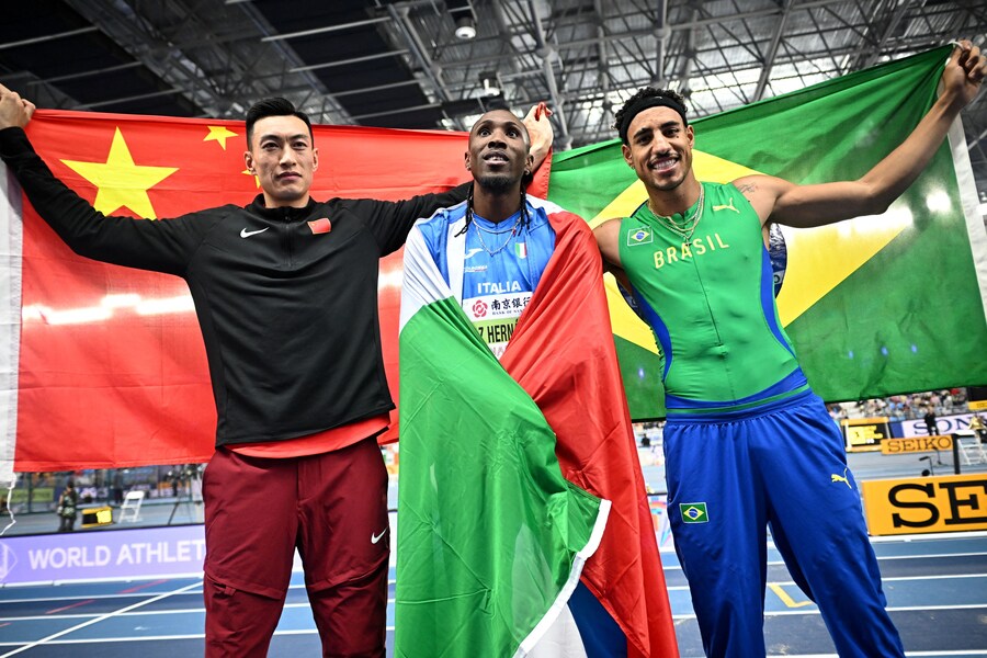 Nanjing Youth Olympic Sports Park, Nanjing, Cina - 21 marzo 2025 L’italiano Andy Diaz Hernandez festeggia la vittoria nel salto triplo maschile insieme al cinese Yaming Zhu, secondo classificato, e al brasiliano Almir Dos Santos, terzo classificato (REUTERS/Dylan Martinez) (REUTERS)
