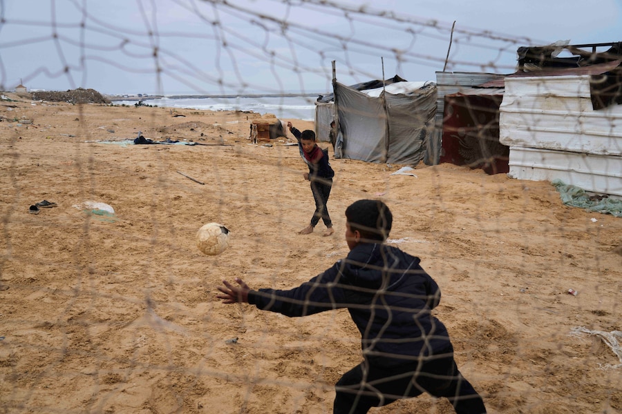 Ragazzi palestinesi sfollati giocano a calcio in un campo profughi improvvisato a Deir al-Balah, nella Striscia di Gaza. (AP Photo/Abdel Kareem Hana) (APN)