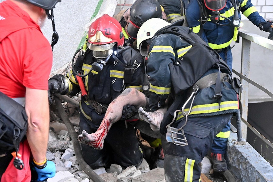 I soccorritori trasportano un ferito dalle rovine di una fabbrica civile in seguito ai potenti attacchi russi sulla città ucraina di Kharkiv (AFP)