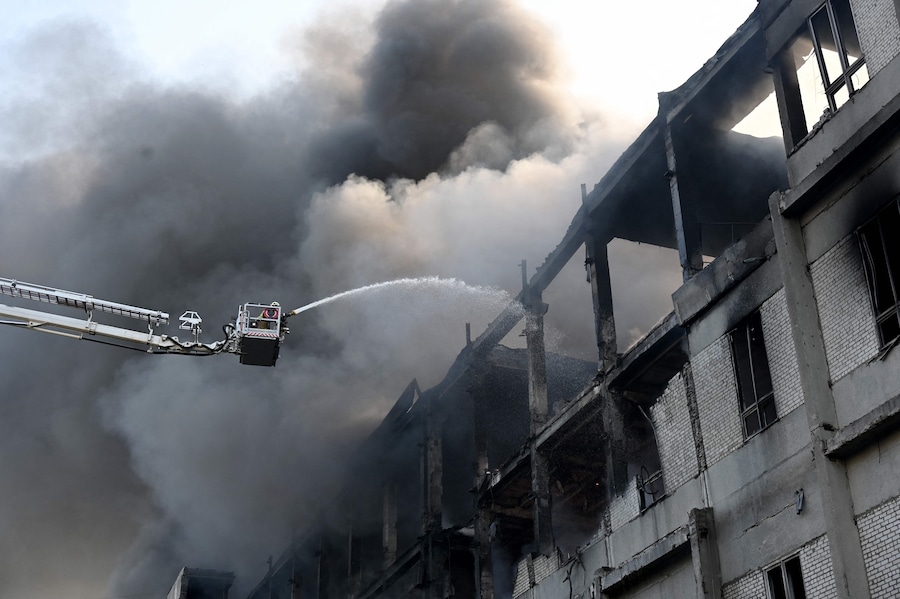 Un pompiere spegne un incendio in una struttura civile in seguito ai potenti attacchi russi sulla città ucraina di Kharkiv (AFP)