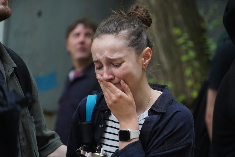 Una donna piange mentre osserva un edificio a più piani danneggiato da un attacco russo a Kharkiv, Ucraina (APN)