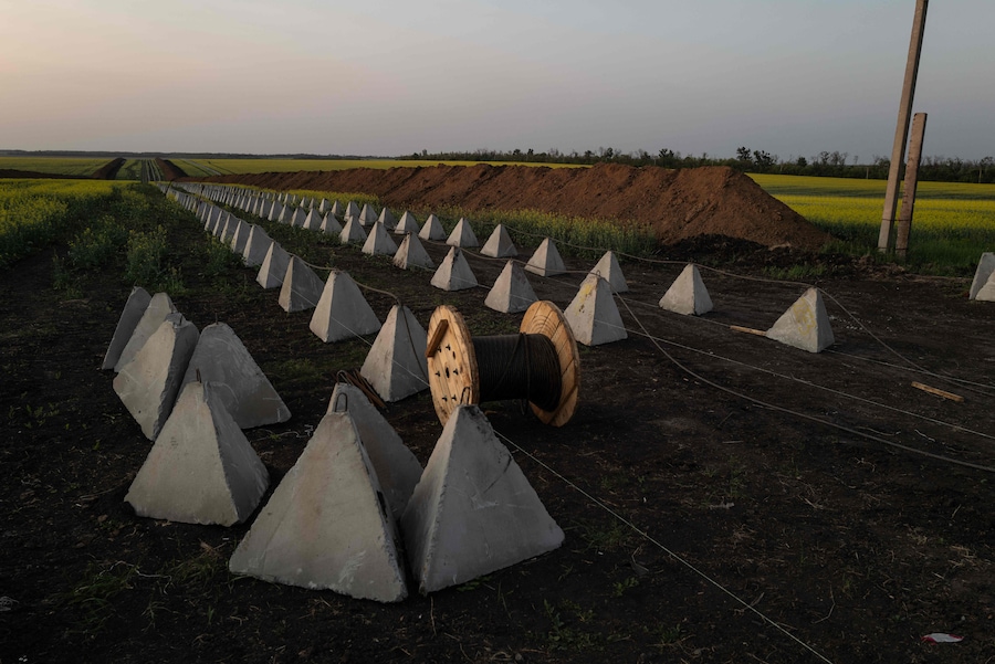 La difesa anticarro ucraina in cemento “Denti di Drago” e le trincee durante la costruzione di nuove linee difensive, che attraversano un campo di colza in una località sconosciuta nell’Ucraina orientale (AFP)