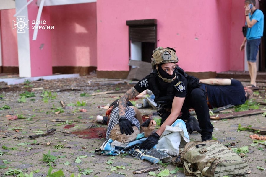 Un agente di polizia presta i primi soccorsi a un residente ferito durante un attacco aereo russo a Kharkiv, Ucraina (via REUTERS)