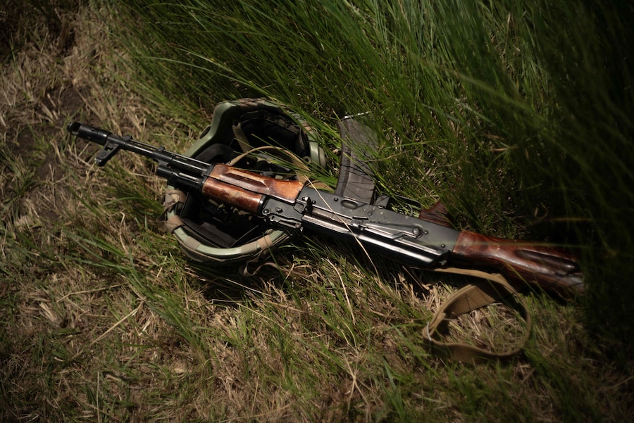 Un elmetto militare e un fucile d’assalto Kalashnikov a terra durante un’esercitazione della 33ª Brigata Meccanizzata Separata ucraina in una località sconosciuta nell’Ucraina orientale (AFP)