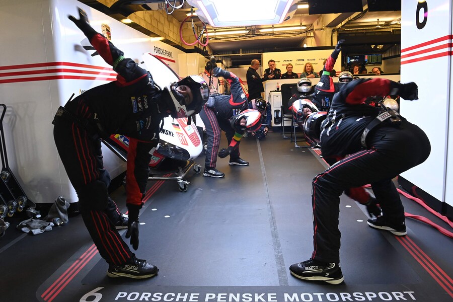 Mechanics warm up before changing tires on Porsche Penske Motorsport Thor Team's hypercar #06 in their pit during the 2025 Le Mans 24 hour endurance race, at the Le Mans circuit, in northwestern France, on June 14, 2025. (Photo by JEAN-FRANCOIS MONIER / AFP) (AFP)