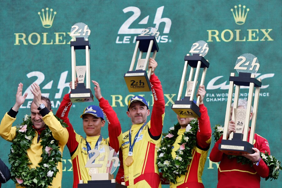AF Corse car a Ferrari 499P, Robert Kubica, center, Yifei Ye, center left, and center right, Phil Hanson celebrate on the podium after winning the 24-hour Le Mans endurance race, Sunday June 15, 2025 in Le Mans, western France. (AP Photo/Jeremias Gonzalez) Associated Press/LaPresse (APS)