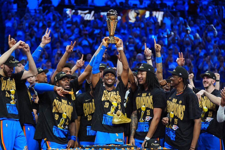 Oklahoma City Thunder guard Shai Gilgeous-Alexander, center, holds up the MVP trophy as he celebrates with his team after they won the NBA basketball championship with a Game 7 victory against the Indiana Pacers Sunday, June 22, 2025, in Oklahoma City. (AP Photo/Julio Cortez) Associated Press/LaPresse (APS)