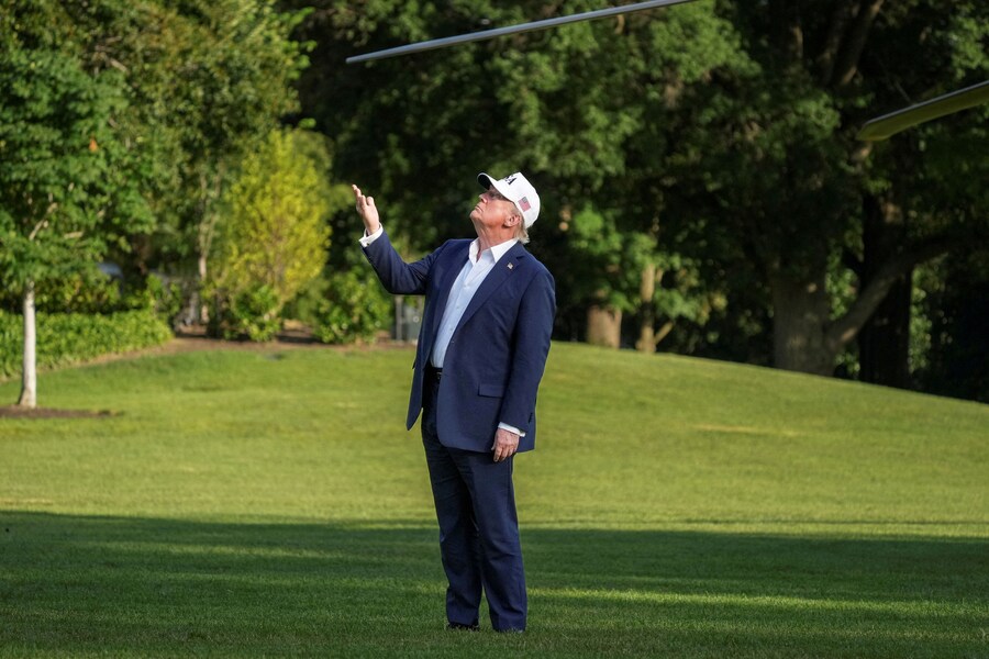 Il presidente degli Stati Uniti Donald Trump fa un gesto verso la bandiera statunitense che sventola su un nuovo pennone dopo essere sceso dal Marine One di ritorno dal New Jersey alla Casa Bianca a Washington. (REUTERS)