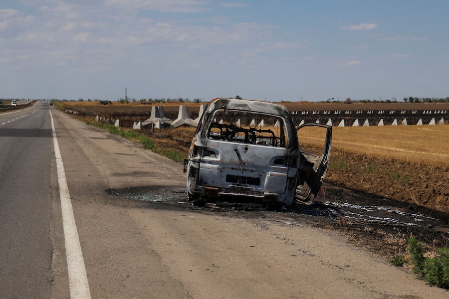 I resti di un'auto bruciata si trovano sul ciglio della strada vicino a fortificazioni anticarro chiamate "denti di drago" e tetrapodi, sull'autostrada Mykolaiv-Kherson nella regione di Kherson, Ucraina. (REUTERS/Ivan Antypenko)