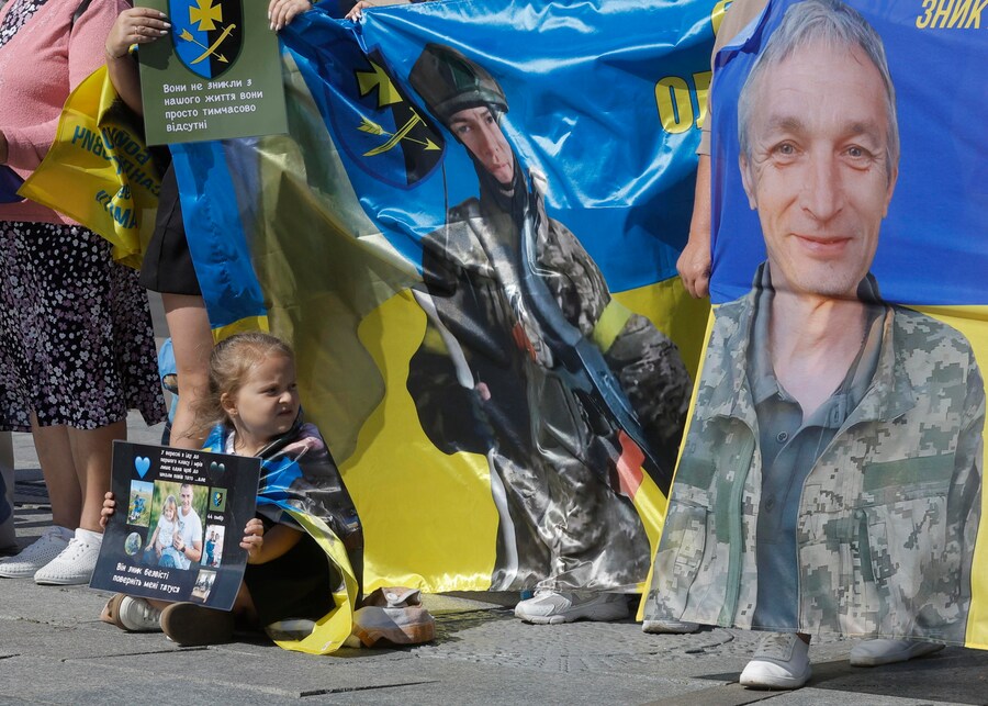 Una bambina tiene un cartello con la richiesta di ritrovare suo padre durante un'azione a sostegno dei prigionieri di guerra e delle persone scomparse nella Piazza dell'Indipendenza nel centro di Kiev, Ucraina, il 23 agosto 2025. L'Ucraina ha celebrato la Giornata nazionale della bandiera in mezzo all'invasione russa in corso. L'Ucraina celebra la Giornata nazionale della bandiera il 23 agosto di ogni anno. (EPA/Sergey Dolzhenko)