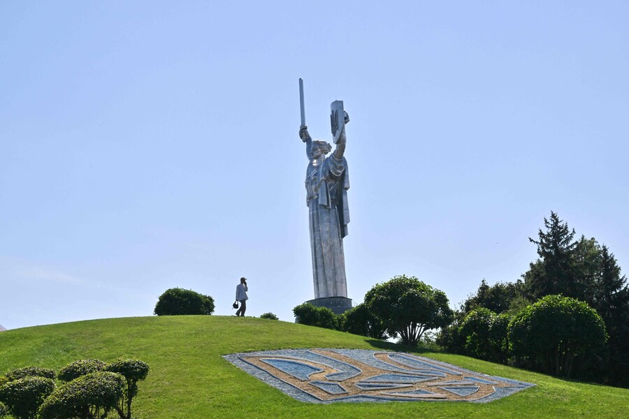 Un uomo cammina davanti al Monumento della Madrepatria a Kiev il 23 agosto 2025, un giorno prima della Giornata dell'Indipendenza dell'Ucraina, nel contesto dell'invasione russa in Ucraina. (Sergei Supinsky / AFP)