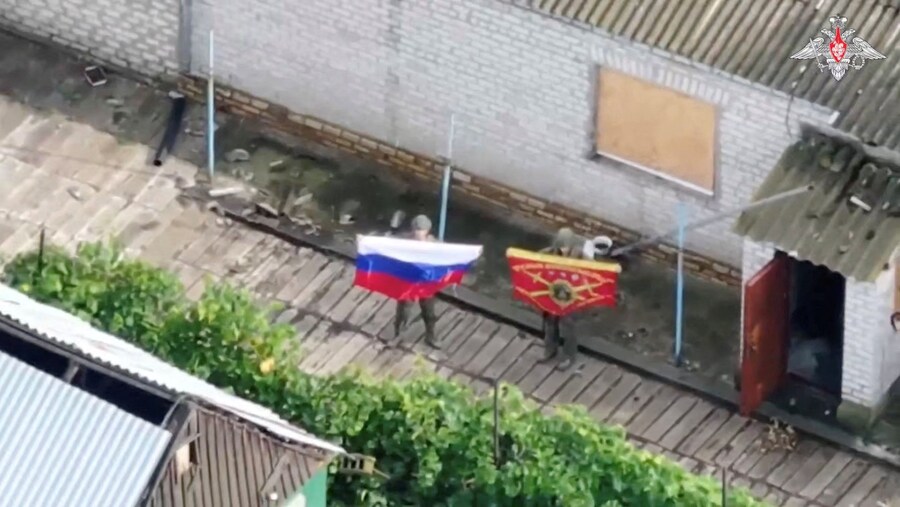 Un fermo immagine, tratto da un filmato rilasciato dal Ministero della Difesa russo, mostra quelli che, a detta del Ministero, sono soldati russi che espongono bandiere, dopo la cattura dell'insediamento ucraino di Zaporizke, nella regione di Dnipropetrovsk. (via REUTERS)