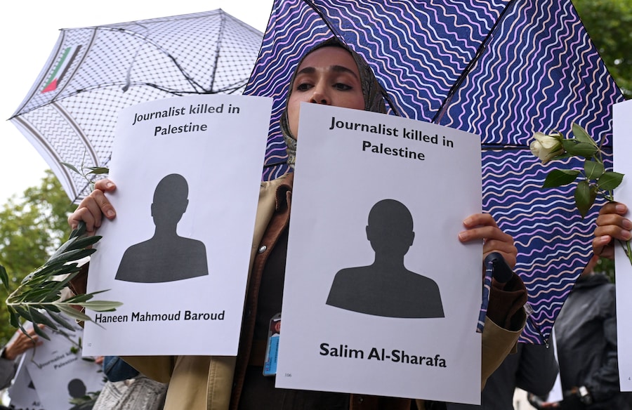Una donna regge dei cartelli con i nomi dei giornalisti palestinesi uccisi Haneen Mahmoud Baroud e Salim al-Sharafa, mentre le persone partecipano a una veglia davanti al numero 10 di Downing Street, organizzata dalla National Union of Journalists London Freelance Branch, per ricordare i quasi 200 giornalisti uccisi a Gaza dall'ottobre 2023, secondo il Committee to Protect Journalists, a Londra, Gran Bretagna. REUTERS/Jaimi Joy (REUTERS)