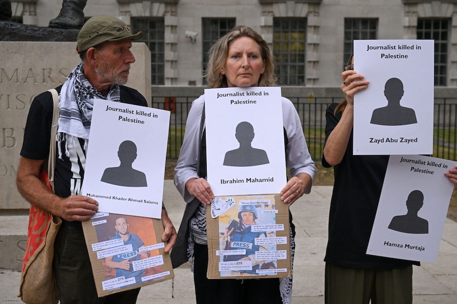 Persone tengono in mano cartelli con i nomi dei giornalisti palestinesi uccisi, mentre partecipano a una veglia davanti al numero 10 di Downing Street, organizzata dalla National Union of Journalists London Freelance Branch, per ricordare i quasi 200 giornalisti uccisi a Gaza dall'ottobre 2023, secondo il Committee to Protect Journalists, a Londra, Gran Bretagna. REUTERS/Jaimi Joy (REUTERS)