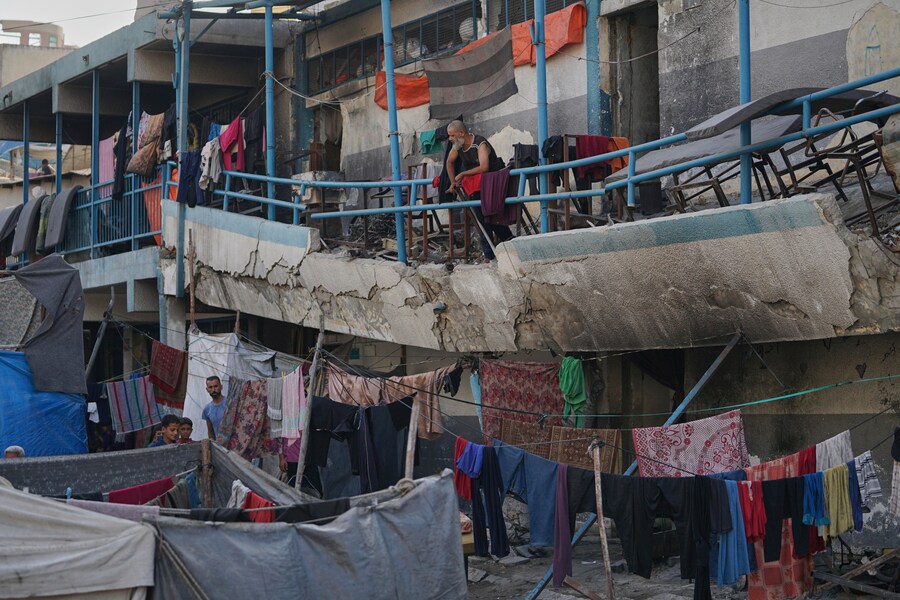 Un uomo palestinese sfollato si trova sul balcone danneggiato di una scuola usata come rifugio, a Gaza City. (Foto AP/Jehad Alshrafi) (APN)