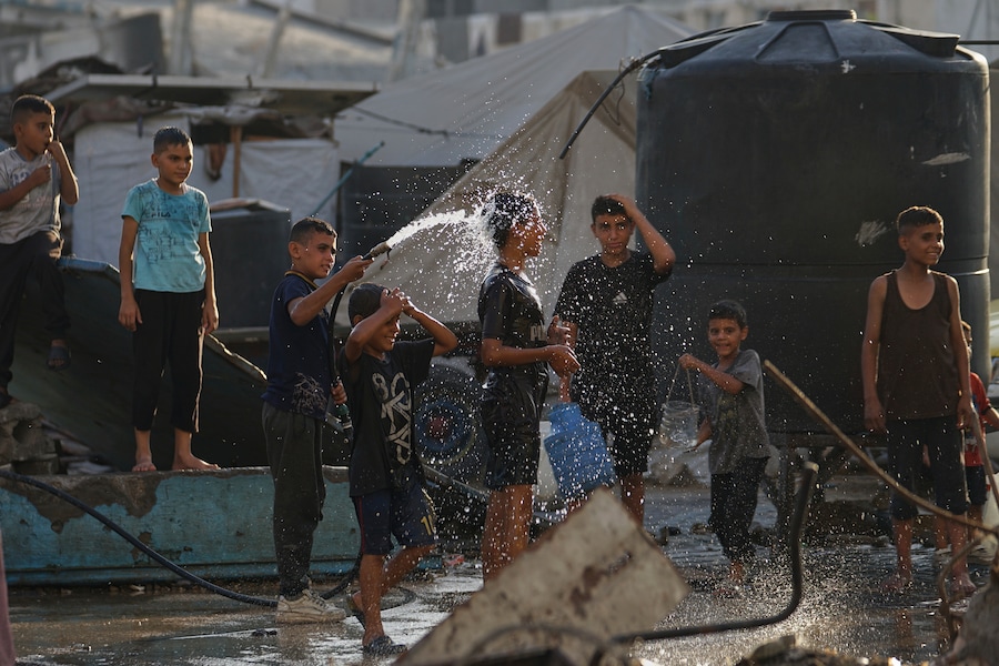 Bambini palestinesi sfollati si rinfrescano in una scuola usata come rifugio a Gaza City. (Foto AP/Jehad Alshrafi) (APN)