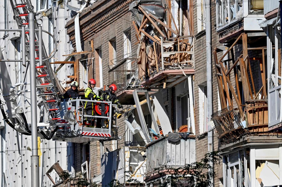 Vigili del fuoco rimuovono le macerie di un edificio residenziale in un'area danneggiata della capitale ucraina a seguito di un attacco di droni e missili russi su larga scala a Kiev il 28 agosto 2025. (AFP)