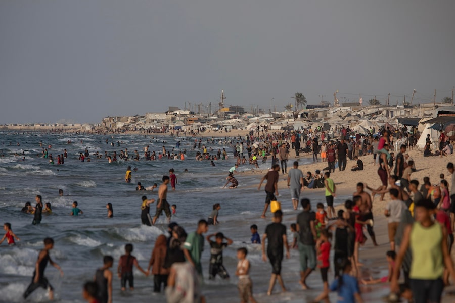 Palestinesi sfollati fanno il bagno in mare sulla spiaggia del campo di Khan Younis, nel sud della Striscia di Gaza. (EPA)