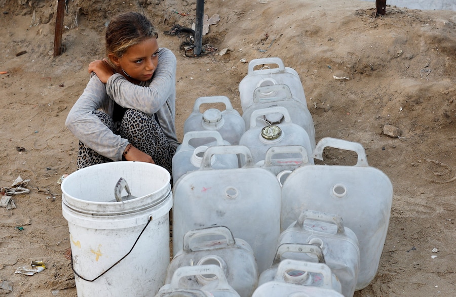 Una ragazza palestinese sfollata aspetta di raccogliere l'acqua dopo che Hamas ha accettato di rilasciare gli ostaggi e di accettare alcuni altri termini in un piano statunitense per porre fine alla guerra. (REUTERS)