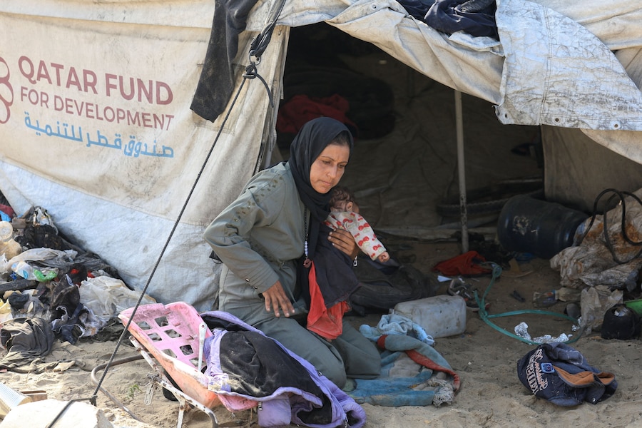 Un palestinese sfollato siede accanto a una tenda. (REUTERS)
