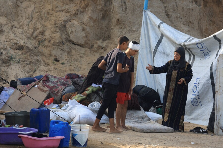 Palestinesi sfollati si riparano sul ciglio di una strada, dopo che Hamas ha accettato di rilasciare gli ostaggi e di accettare alcuni altri termini di un piano statunitense per porre fine alla guerra, nella Striscia di Gaza centrale. (REUTERS)