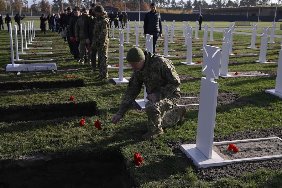 Deposizione di fiori durante la cerimonia funebre per soldati ucraini non identificati presso il Cimitero Nazionale Militare Memoriale vicino a Kiev (AFP)