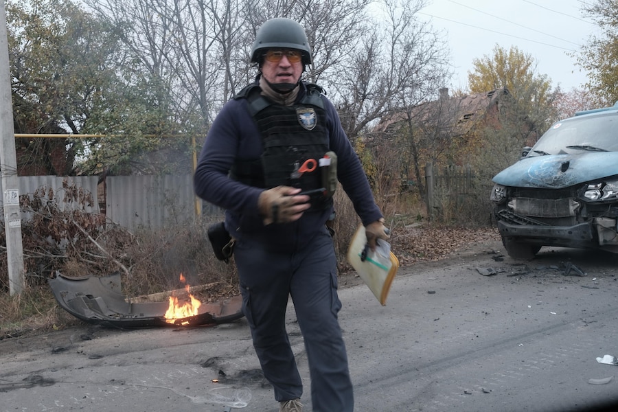 I membri del team della missione umanitaria “Proliska” sul posto poco dopo che il loro veicolo è stato colpito da un drone FPV russo nella città di Kostyantynivka, in prima linea, nella regione di Donetsk, nell’Ucraina orientale (EPA)