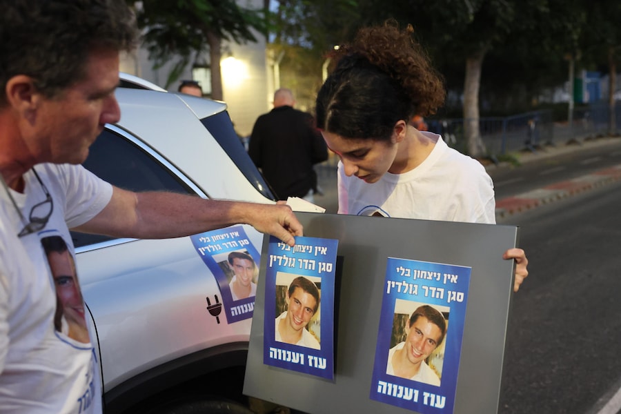 Sostenitori con striscioni con l'immagine del soldato israeliano Hadar Goldin aspettano che un convoglio che trasporta un corpo rilasciato dalle Brigate al-Qassam, l'ala militare di Hamas, arrivi al Centro nazionale di medicina legale di Tel Aviv, Israele, 09 novembre 2025. Hamas sostiene che il corpo appartiene al soldato israeliano Hadar Goldin, ucciso nella guerra di Gaza del 2014. Israele non ha ancora verificato positivamente i resti. EPA/ABIR SULTAN (EPA)