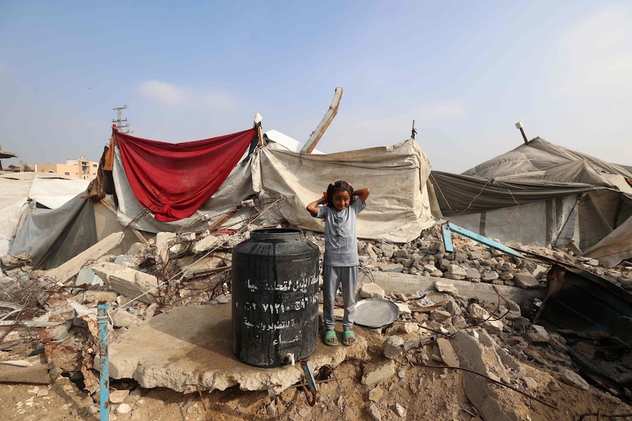 Una ragazza palestinese si spazzola i capelli mentre si trova vicino a un barile d'acqua vicino al campo profughi di Nuseirat, nel centro della Striscia di Gaza, il 9 novembre 2025, dopo la tregua promossa dagli Stati Uniti che ha fermato la guerra di due anni. La prima fase dell'accordo per il cessate il fuoco a Gaza, mediato il mese scorso dal Presidente degli Stati Uniti, ha aperto la strada allo scambio di ostaggi israeliani e prigionieri palestinesi. (Foto di Eyad Baba / AFP) (AFP)