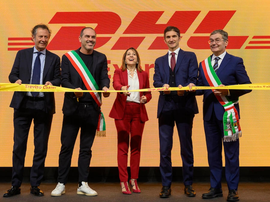 6 - Il taglio del nastro sul palco: al centro, Nazzarena Franco – CEO DHL Express Italy; da sinistra, Luca Fiorini, <i>Vicepresidente Confindustria Veneto Est, Presidente della Piccola e Media Industria e del Gruppo Trasporti, Logistica, Portualità</i>, Alessandro Manera, <i>Vicesindaco di Treviso con deleghe allo Sport, Politiche Comunitarie e Sostenibilità Ambientale</i>; da destra, Renzo Carraretto – <i>Sindaco di Casier</i>, Leopoldo Destro – <i>Delegato del Presidente di Confindustria a Trasporti, Logistica, Industria del Turismo e della Cultura.</i>