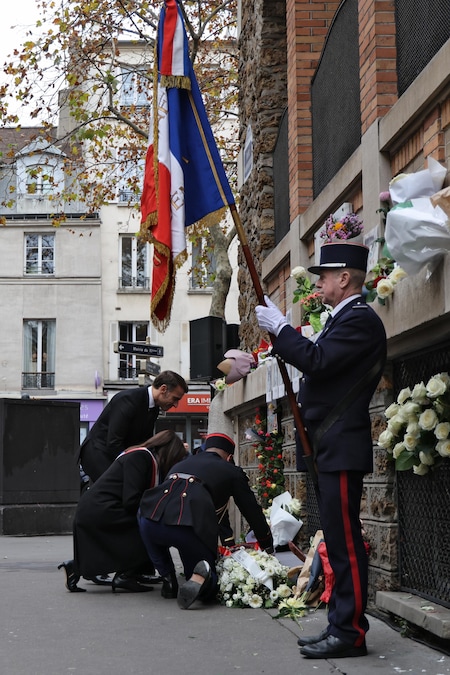 Il presidente francese Emmanuel Macron (a sinistra) e il sindaco di Parigi Anne Hidalgo (2-S) depongono una corona di fiori accanto a una targa commemorativa fuori La Belle Equipe, uno dei siti presi di mira negli attacchi di Parigi del novembre 2015 (EPA)