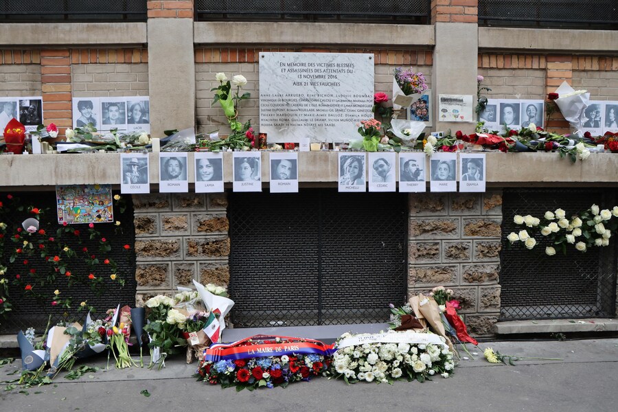 Corone di fiori poste accanto ai ritratti delle vittime e una targa commemorativa all’esterno di La Belle Equipe, uno dei siti presi di mira negli attacchi di Parigi del novembre 2015, durante una cerimonia a Parigi, Francia (EPA)