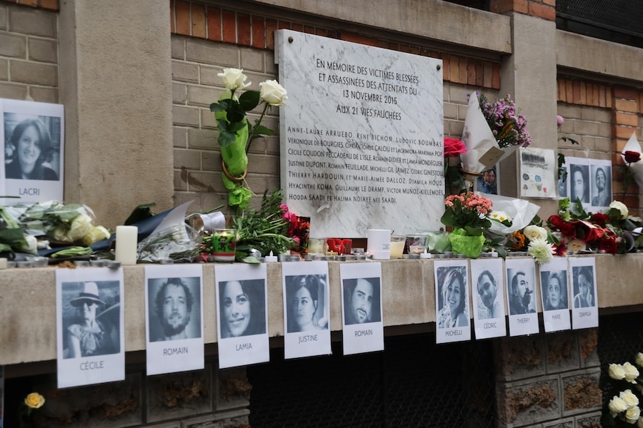 Dei fiori giacciono vicino ai ritratti delle vittime e a una targa commemorativa vicino a uno dei siti presi di mira negli attacchi di Parigi del novembre 2015, durante una cerimonia a Parigi, Francia (EPA)