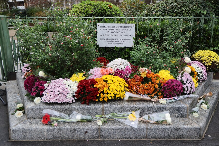 Fiori deposti davanti a una targa commemorativa in un incrocio vicino al Café Bonne Biere, uno dei luoghi presi di mira negli attacchi di Parigi del novembre 2015, per una cerimonia in omaggio alle vittime a Parigi, Francia (EPA)