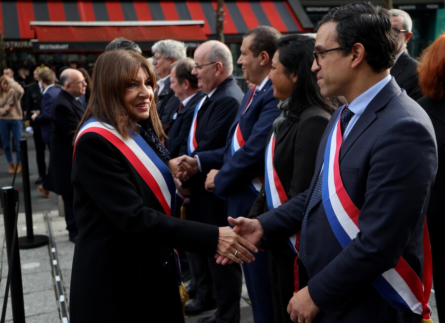 Il sindaco di Parigi Anne Hidalgo (a sinistra) stringe la mano ai funzionari fuori dallo Stade de France, durante una cerimonia in omaggio alle vittime degli attacchi di Parigi del novembre 2015, a Saint-Denis, sobborgo settentrionale di Parigi, Francia (EPA)