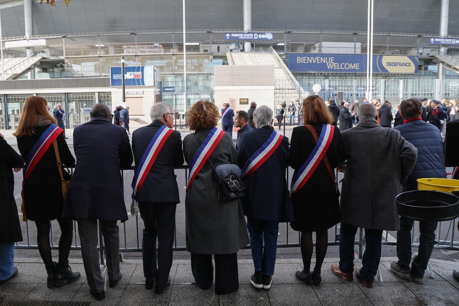 I rappresentanti locali del dipartimento della Senna-Saint-Denis assistono a una cerimonia fuori dallo Stade de France in omaggio alle vittime degli attacchi di Parigi del novembre 2015, a Saint-Denis, sobborgo settentrionale di Parigi (EPA)