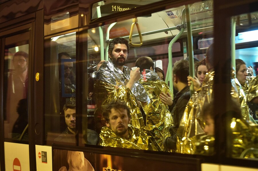 Persone vengono evacuate in autobus fuori dalla scena di un attacco al teatro Bataclan di Parigi, Francia, 13 novembre 2015 (EPA)