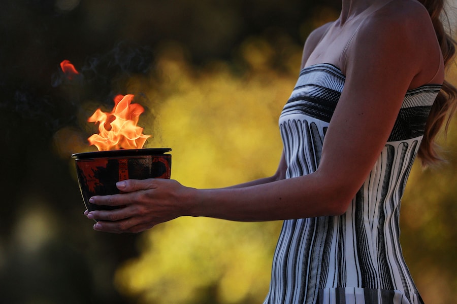 Olimpiadi - Olimpiadi invernali di Milano-Cortina 2026 - Prova generale della cerimonia di accensione della fiamma olimpica - Antica Olimpia, Grecia - 24 novembre 2025 Una performer nel ruolo di una sacerdotessa porta la fiamma olimpica durante la prova generale in vista della cerimonia REUTERS/Louisa Gouliamaki (REUTERS)
